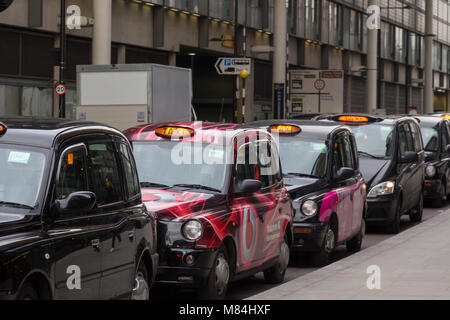 Parcheggiato London Black Cab taxi in attesa di una tariffa vicino a Kings Cross Station con taxi illuminato di luce. Foto Stock