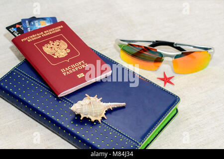 Red Passaporto russo con carte di credito, bicchieri e conchiglie. Il concetto di viaggio Foto Stock