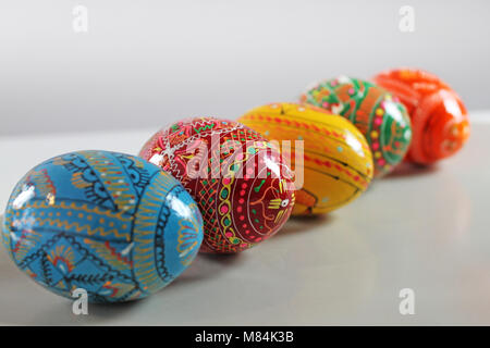 Colorata a mano le uova di pasqua in fila su sfondo bianco. Ceca tradizionale decorazione di pasqua. Foto Stock