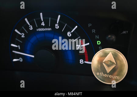 Ethereum moneta in oro su un auto cruscotto con tachimetro giri. Foto Stock