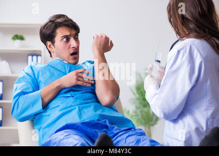 Paura uomo paziente ottenere pronto per il vaccino antinfluenzale Foto Stock