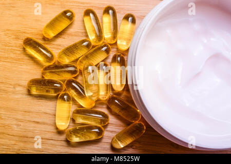 Set di crema di cura e di olio di pesce di capsule con omega 3 e vitamina D. La bellezza e il concetto di salute Foto Stock