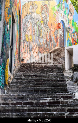 Murale colorato dipinto su una parete accanto a stretti e tortuosi passaggi a Guanajuato, Messico Foto Stock