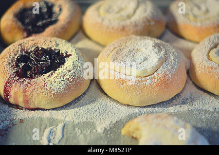 Fresche dolci ciambelle con marmellata e latticini, appena al di fuori del forno, per bambini Foto Stock