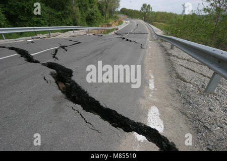 Collassa su strada con enormi crepe. Strada internazionale è crollato giù dopo una brutta costruzione. Danneggiato Highway Road. Strada asfaltata è crollato e caduto. Foto Stock