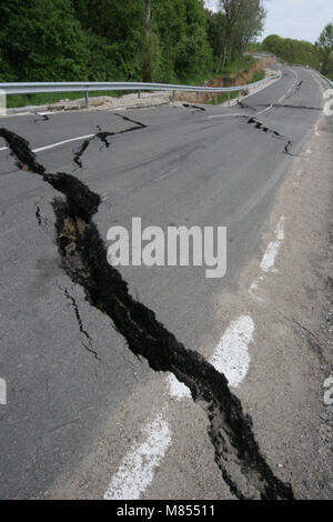 Collassa su strada con enormi crepe. Strada internazionale è crollato giù dopo una brutta costruzione. Danneggiato Highway Road. Strada asfaltata è crollato e caduto. Foto Stock