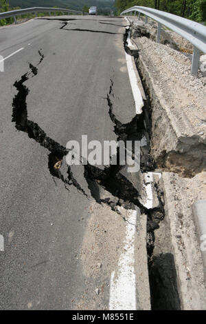 Collassa su strada con enormi crepe. Strada internazionale è crollato giù dopo una brutta costruzione. Danneggiato Highway Road. Strada asfaltata è crollato e caduto. Foto Stock