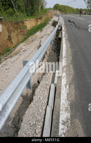 Collassa su strada con enormi crepe. Strada internazionale è crollato giù dopo una brutta costruzione. Danneggiato Highway Road. Strada asfaltata è crollato e caduto. Foto Stock