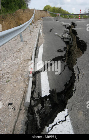 Collassa su strada con enormi crepe. Strada internazionale è crollato giù dopo una brutta costruzione. Danneggiato Highway Road. Strada asfaltata è crollato e caduto. Foto Stock