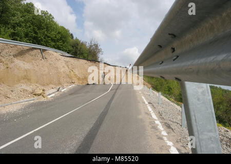 Collassa su strada con enormi crepe. Strada internazionale è crollato giù dopo una brutta costruzione. Danneggiato Highway Road. Strada asfaltata è crollato e caduto. Foto Stock