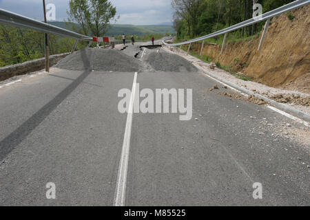 Collassa su strada con enormi crepe. Strada internazionale è crollato giù dopo una brutta costruzione. Danneggiato Highway Road. Strada asfaltata è crollato e caduto. Foto Stock