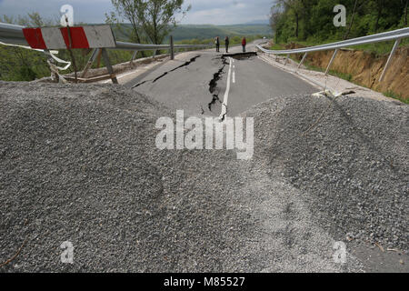 Collassa su strada con enormi crepe. Strada internazionale è crollato giù dopo una brutta costruzione. Danneggiato Highway Road. Strada asfaltata è crollato e caduto. Foto Stock