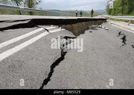 Collassa su strada con enormi crepe. Strada internazionale è crollato giù dopo una brutta costruzione. Danneggiato Highway Road. Strada asfaltata è crollato e caduto. Foto Stock