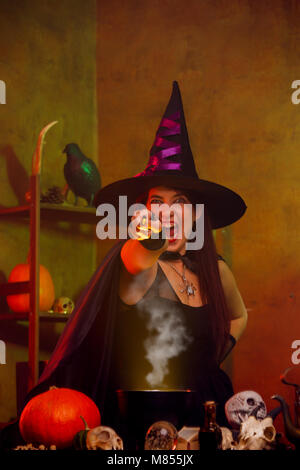 Immagine della strega in black hat con mano tesa con la bacchetta magica Foto Stock