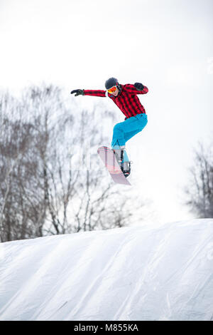 Immagine dell'atleta di equitazione casco snowboard dal pendio di neve Foto Stock