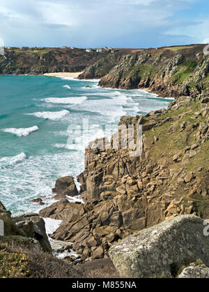 Onde, surf e rocciose scogliere del mare come visto dal sentiero costiero avvicinando Porthcurno beach in distanza, Cornwall, Regno Unito Foto Stock