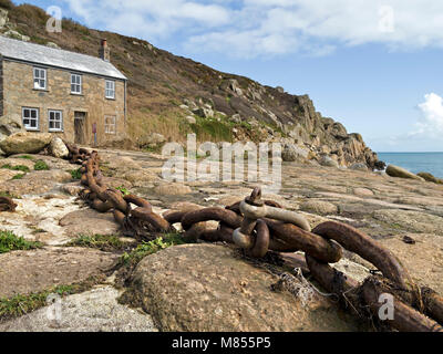 Vecchio arrugginito ormeggio barche catena e Cornish cottage, Penberth Cove, South Cornwall, Inghilterra, Regno Unito. La posizione era usato durante le riprese di Poldark serie TV. Foto Stock