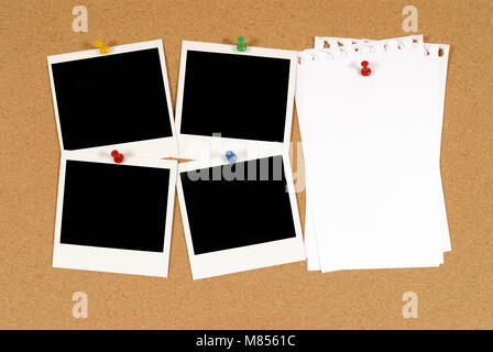 Avviso di sughero o bulletin board con quattro vuoto fotocamera istantanea stampe fotografiche e diversi fogli di disordinato notepaper strappato. Spazio per la copia. Foto Stock