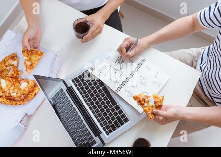 Il pranzo e la gente del concetto. Happy business team di mangiare la pizza in ufficio Foto Stock