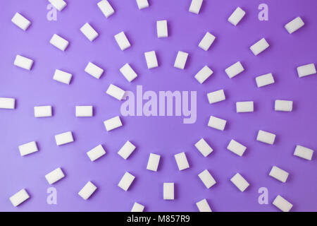 Zucchero bianco i cubi su sfondo viola Foto Stock