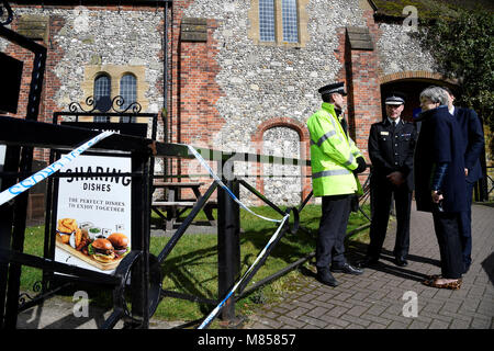 Il primo ministro Theresa Maggio sorge al di fuori il mulino pub come ha vedute della zona della sospetta presenza di agente nervino attacco su russo double agent Sergei Skripal e sua figlia Eleonora. Foto Stock