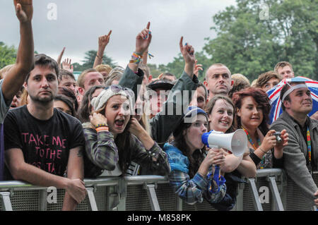 Una folla di persone con le mani in aria a V festival in Staffordshire, Regno Unito in attesa in prima fila per vedere live agisce sul palco Foto Stock