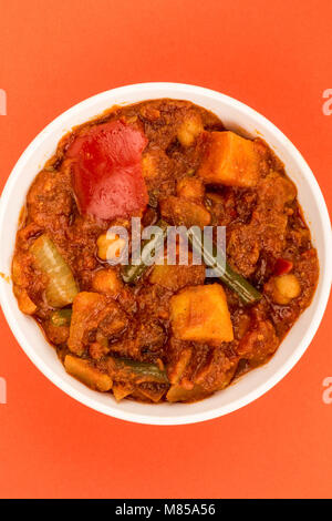 Stile Indiano Vegetariano Masala Curry contro uno sfondo rosso con spazio di copia Foto Stock