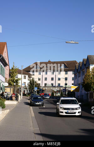 Nieder-Olm, Germania - 14 Ottobre 2017: il traffico sulla parrocchia street in Nieder-Olm con adiacenti degli edifici residenziali e commerciali della città Foto Stock