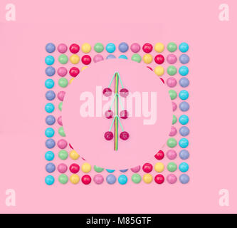 Un assortimento di caramelle colorate su sfondo rosa. Foto Stock