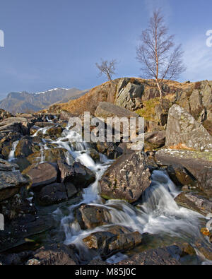Una piccola cascata e scogli nelle vicinanze Llyn Idwal, Snowdonia, il Galles del Nord in una giornata di sole in primavera Foto Stock
