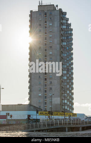 Il sole del peering intorno a Arlington casa a torre, costruita nel 1964, sul lungomare a Margate, Kent, Regno Unito. Foto Stock