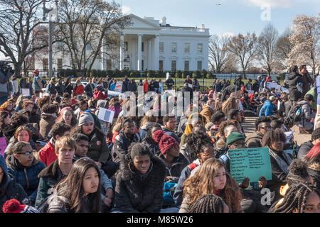 Washington, DC, Stati Uniti d'America. Il 14 marzo 2018. Gli studenti dall'area scuole superiori di sedersi con spalle alla Casa Bianca durante la Scuola Nazionale Walkout, protestando governativo di inazione sul controllo della pistola, mentre la manifestazione di solidarietà per i 17 studenti assassinati in Marjory Stoneman Douglas High School nel parco, Florida. I 17 minuti di protesta è stata seguita da un mese di marzo per gli Stati Uniti Capitol. Bob Korn/Alamy Live News Foto Stock