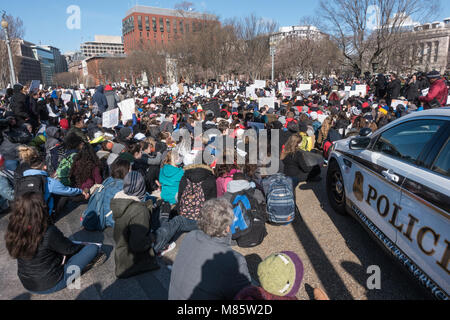 Washington, DC, Stati Uniti d'America. Il 14 marzo 2018. Gli studenti dall'area scuole superiori di sedersi con spalle alla Casa Bianca durante la Scuola Nazionale Walkout, protestando governativo di inazione sul controllo dell'arma, pur mostrando solidarietà fort la17 studenti assassinati in Marjory Stoneman Douglas High School nel parco, Florida. I 17 minuti di protesta è stata seguita da un mese di marzo per gli Stati Uniti Capitol. Bob Korn/Alamy Live News Foto Stock