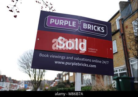 Un viola mattoni venduti agente immobiliare segno esterno di una casa a Muswell Hill, Londra Foto Stock