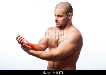 Dolore al polso. Giovane uomo calvo sport physique detiene un braccio malato su un isolato bianco sullo sfondo. Frattura del polso Foto Stock