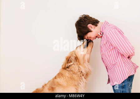 Il golden retriever cane leccare un ragazzo del viso Foto Stock