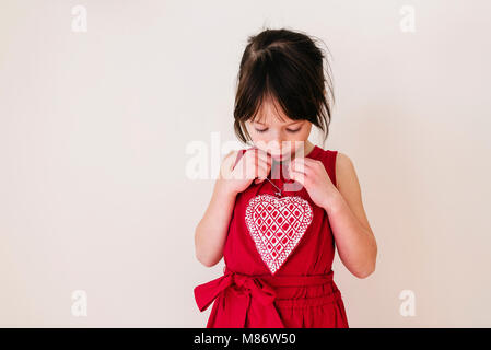 Sorridente ragazza con una forma di cuore decorazione Foto Stock