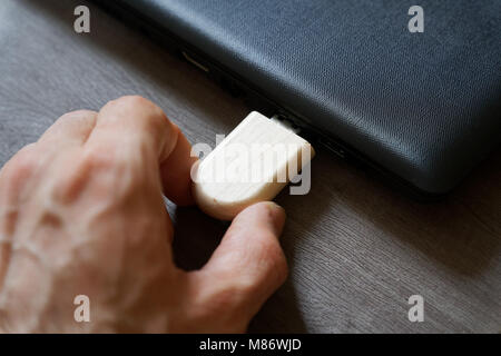 Mano inserire unità flash USB collegati alla porta USB plug-in computer portatile per il trasferimento di dati e backup business concetto. Foto Stock