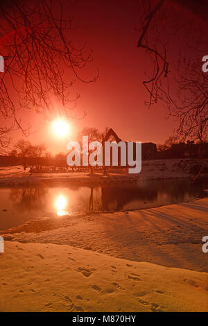 Tramonto a Bolton priory dal fiume wharfe in inverno la neve wharfedale regno unito Foto Stock