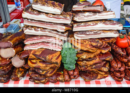 In casa la pancetta affumicata, salsicce e verdure sul tavolo esposto per la vendita. Foto Stock