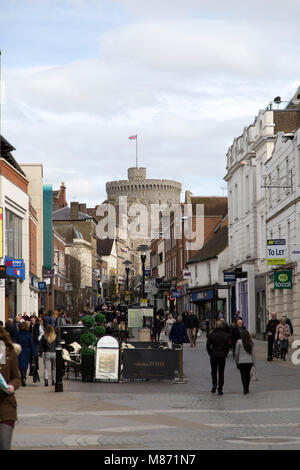 Persone su Peascod Street a Windsor, in Inghilterra. Il Castello di Windsor, una residenza reale può essere visto dalla strada. Foto Stock