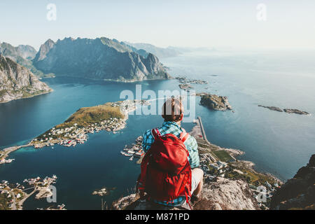 Uomo seduto sul bordo scogliera da soli godendo di vista aerea backpacking lifestyle travel adventure outdoor vacanze estive in Norvegia top di mou Reinebringen Foto Stock