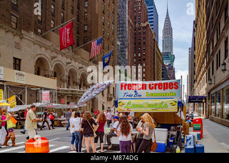 Persone che acquistano Crepes francese a un mercato di domenica sulla Lexington Avenue con il Chrysler Building a distanza,Manhattan, New York City Foto Stock