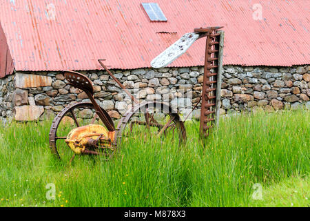 L'annata agricola la falciatura di erba macchina parcheggiata in erba lunga Foto Stock