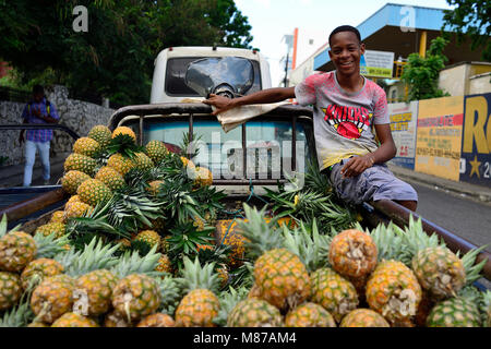 LA ROMANA, REPUBBLICA DOMINICANA - 02 dicembre 2017: Giovani sorridente venditore di ananas che arrivarono in La Romana la città dal vicino villaggio Foto Stock