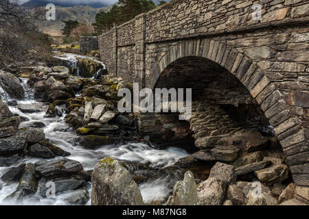 Il vecchio ponte packhorse sotto il ponte principale a Pont Pen y Benglog cascata al Parco Nazionale di Snowdonia, Ogwen, Gwynedd, Galles del Nord, Regno Unito Foto Stock