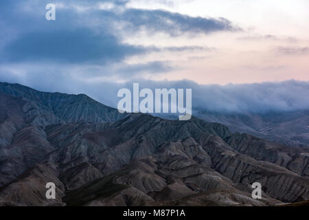 Nuvole sopra le maestose cime di montagna Foto Stock