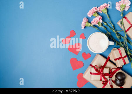 La colazione del mattino per il giorno di San Valentino. Caffè, cioccolatini, confezioni regalo, cuore della carta su sfondo giallo. Vista superiore, piatto laici. Foto Stock