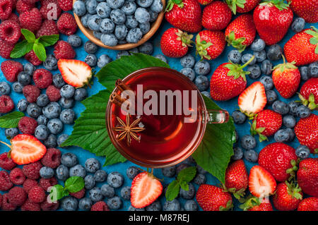 Tè con bacche mix di fragola, mirtillo, lampone e spezie. Varie estate fresca bacche. Vista superiore Foto Stock