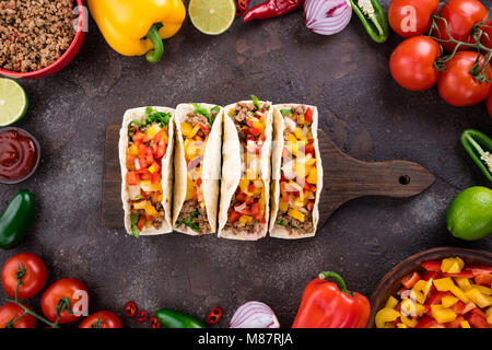 Tacos messicano con verdure e carne. Ingrediente per la cottura di tacos al pastore su sfondo di calcestruzzo. Vista superiore Foto Stock
